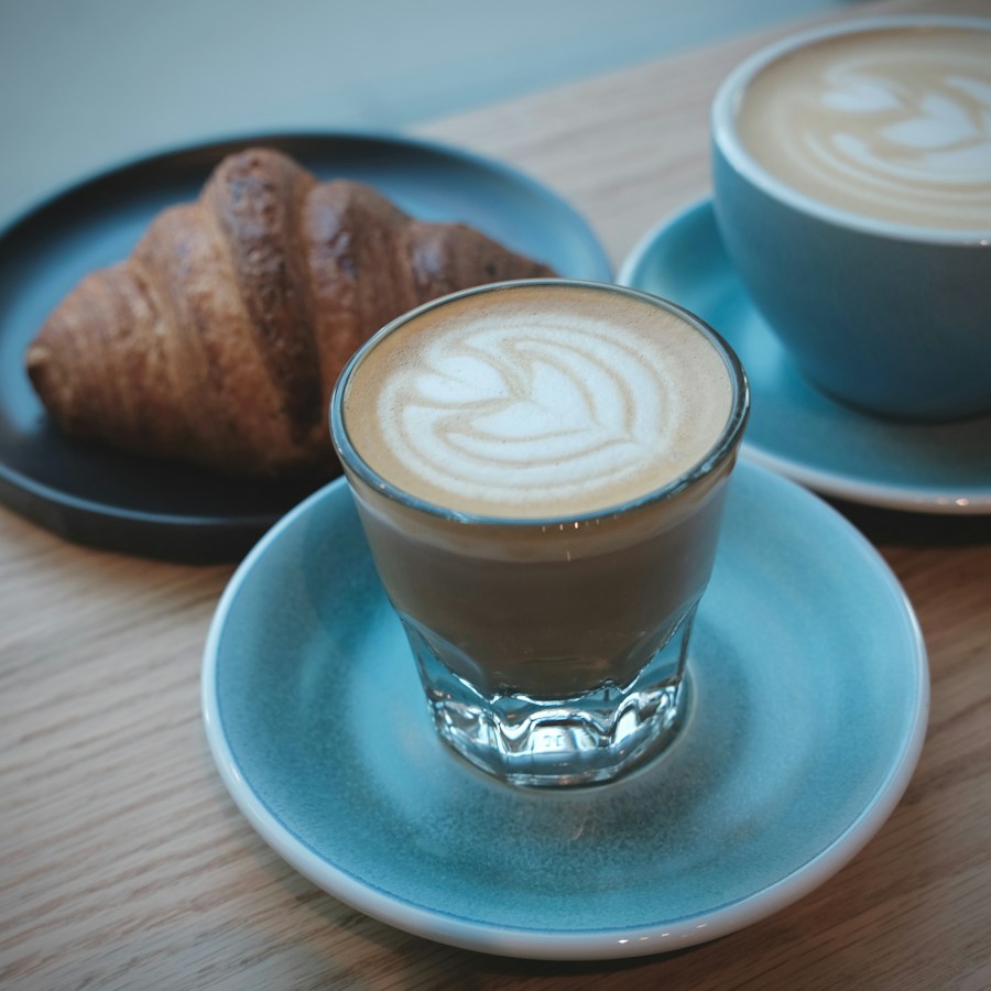 Coffee and a croissant on a blue café table
